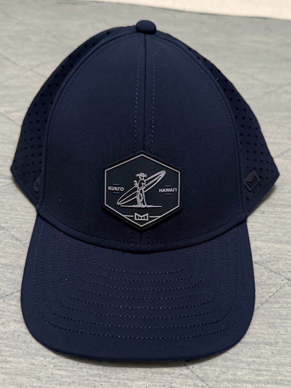 NWT Melin Navy Blue A-Game Hydro 56 cm EUC Hawaii Kukio Golf Course Hat